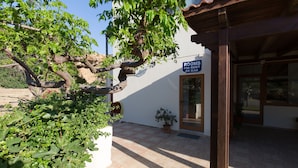A building with a sign reading "ROOMS FOR RENT" and a potted plant in front. - En Plo Rooms (Kissamos)