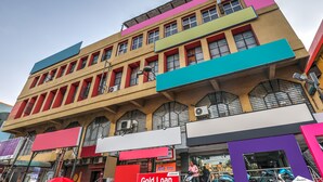 A multi-story building with a flat facade, large windows, and a variety of signage, including a prominent 'Gold Loan' sign. - OYO 14194 Hotel Deccan Lodging and Boarding (Hyderabad)