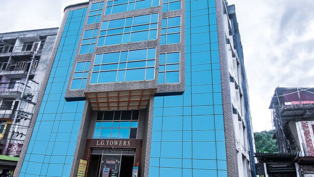 A building with a prominent blue facade and the name "L.G. TOWERS" on the entrance. - OYO 14737 LG Towers (Guwahati)
