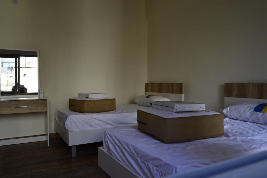 Una habitación de hotel con dos camas, un escritorio y una ventana.