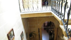 A staircase with a wrought iron railing leading to a lower level. - Nocturne Family House (Paola)