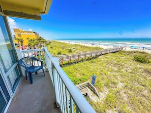 A balcony with a view of a beach and ocean.