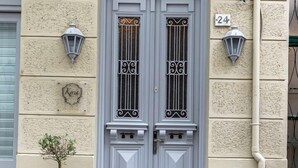 A building with a double door, a small potted plant, and a number '24' sign. - Kyria House (Athens)