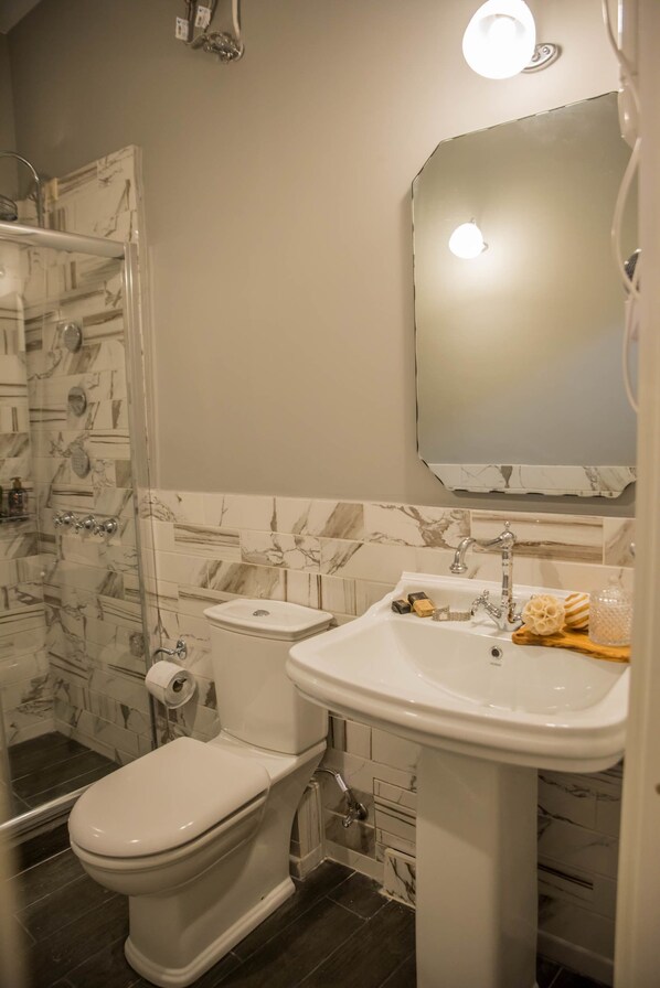 A bathroom with a toilet, sink, and shower. - Kyria House (Athens)