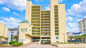 A multi-story hotel with a flat facade, balconies, and a parking garage entrance.