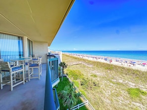 A balcony with a view of a beach, outdoor furniture, and a clear sky. - Emerald Cove II 4B (North Myrtle Beach)