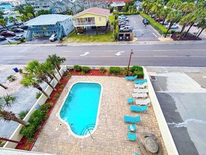 A swimming pool with lounge chairs and a building in the background.