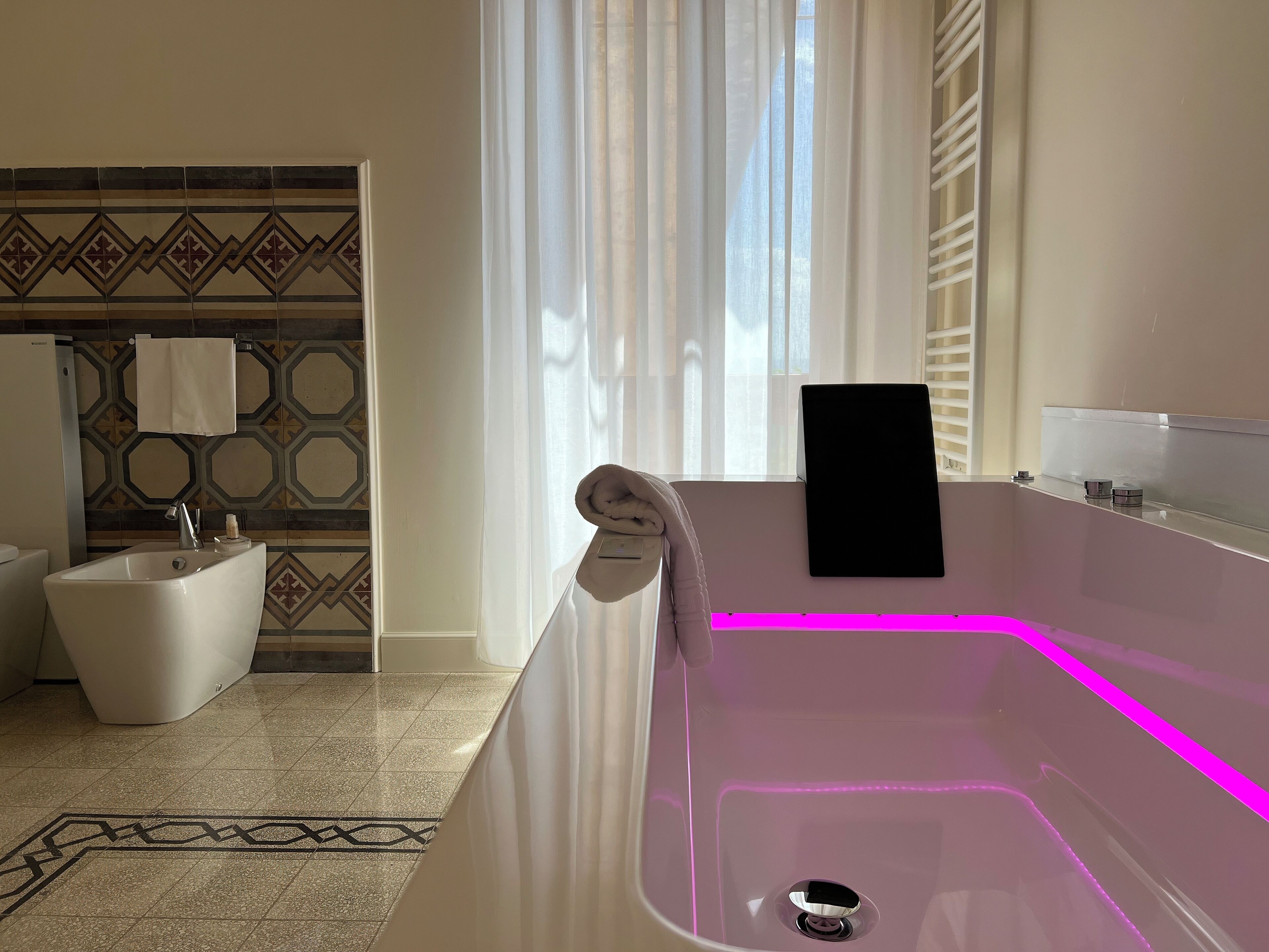 Un baño moderno con una bañera independiente, un lavabo blanco y un inodoro.