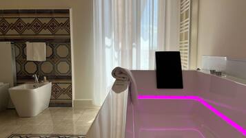 Un baño moderno con una bañera independiente, un lavabo blanco y un inodoro.
