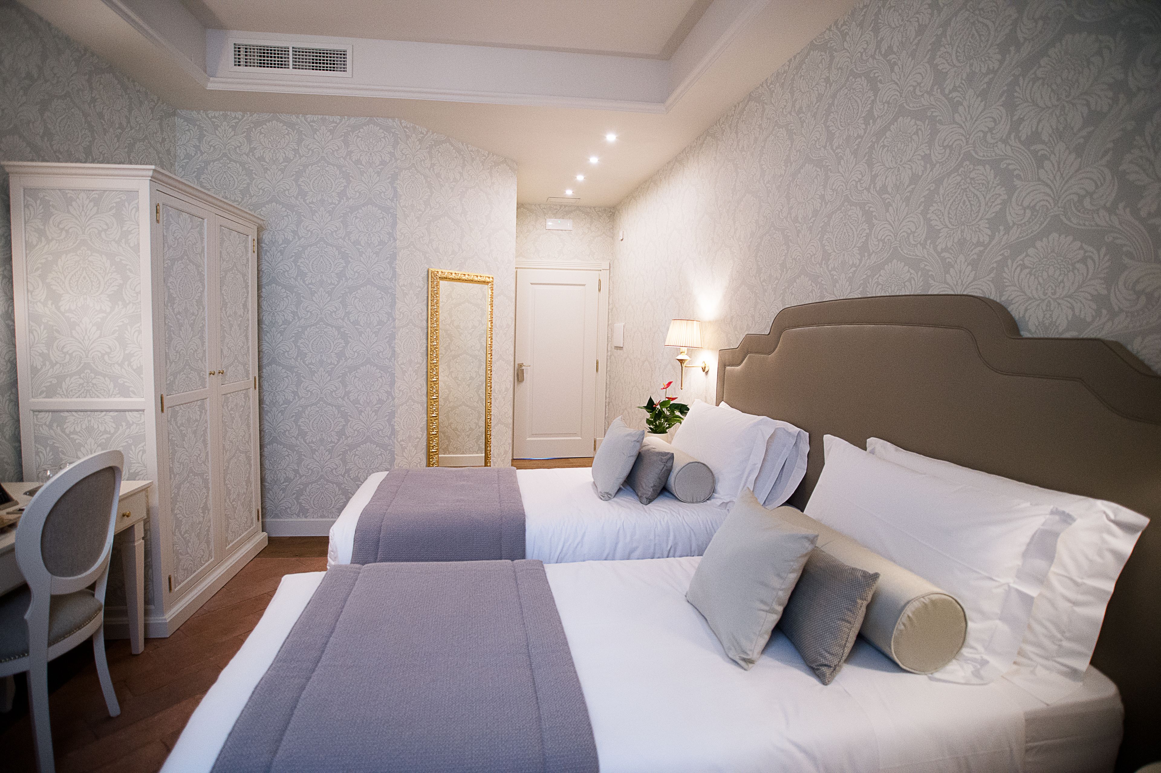 Une chambre d’hôtel avec deux lits, un bureau et une armoire.