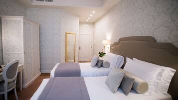 Une chambre d’hôtel avec deux lits, un bureau et une armoire.
