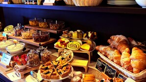 Un bufé con diversas opciones de comida, incluyendo pasteles, postres y una variedad de platos.