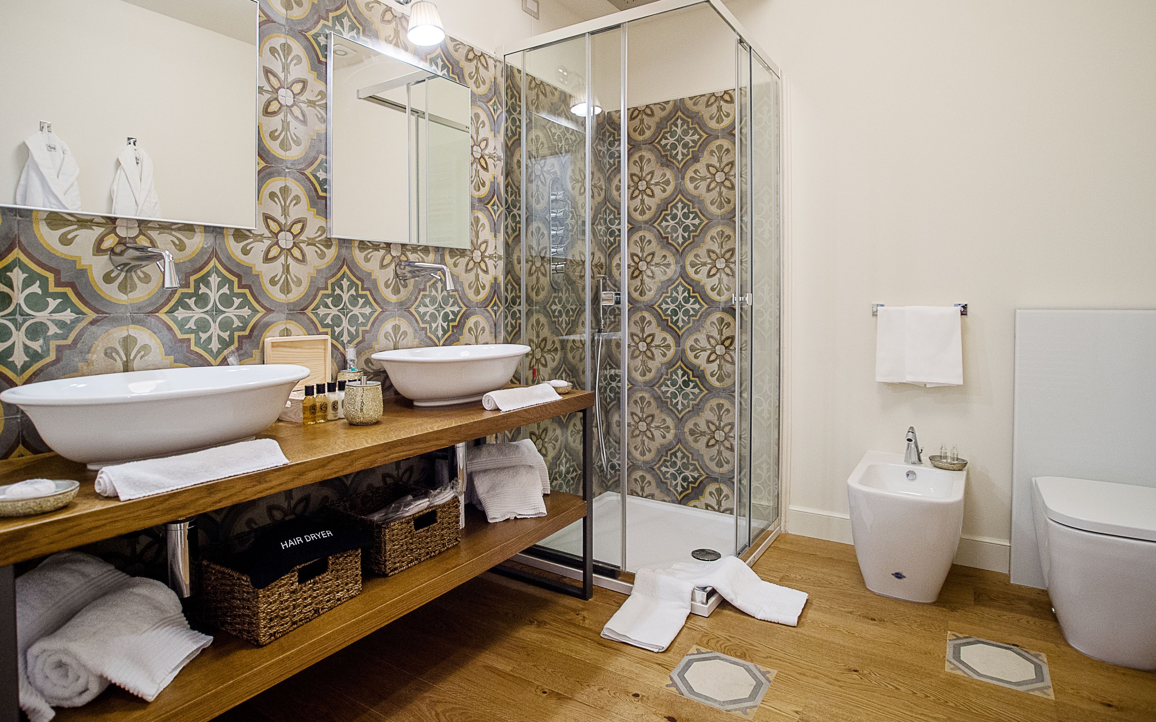 Une salle de bain avec deux lavabos, une douche et des toilettes.