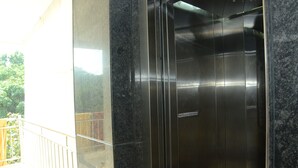 Un ascensor con detalles metálicos y un letrero que indica que es el ascensor para la prensa.