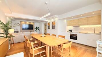 Een moderne keuken met witte kasten, een houten aanrechtblad en een ingebouwde oven.