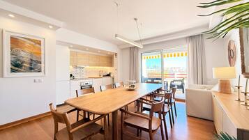 Un appartement moderne comprenant un coin repas, une cuisine et un balcon avec vue sur la ville.