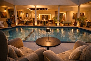 Una piscina al aire libre, sombrillas, sillones reclinables de piscina