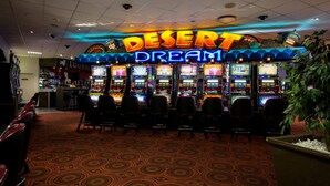 A gaming area with multiple slot machines and a neon sign that reads "DESERT DREAM."