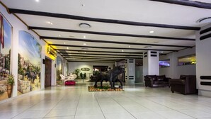 A spacious lobby with a large mural, a statue of a bull, and leather seating.