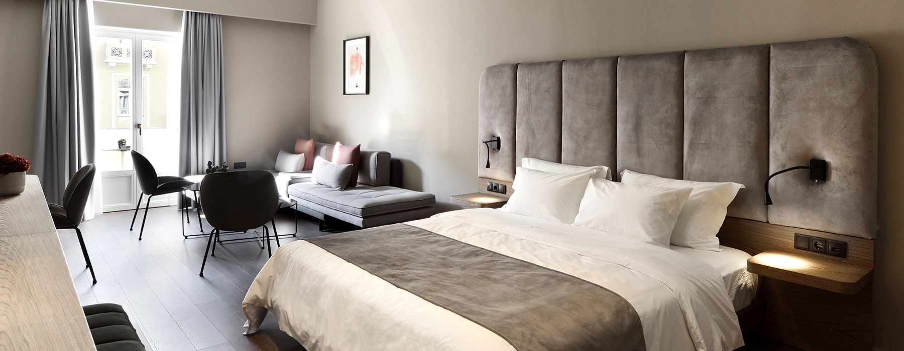 Een moderne hotelkamer met een groot bed, een sofa, een bureau en een stoel.