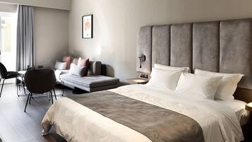 Een moderne hotelkamer met een groot bed, een sofa, een bureau en een stoel.