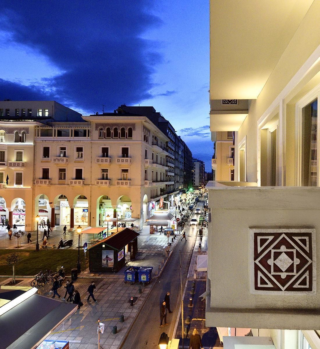Une vue nocturne d’une rue de la ville, avec ses immeubles, ses boutiques et ses piétons.