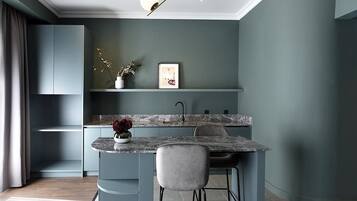 A modern kitchen with a curved island, a built-in sink, and a pendant light fixture.