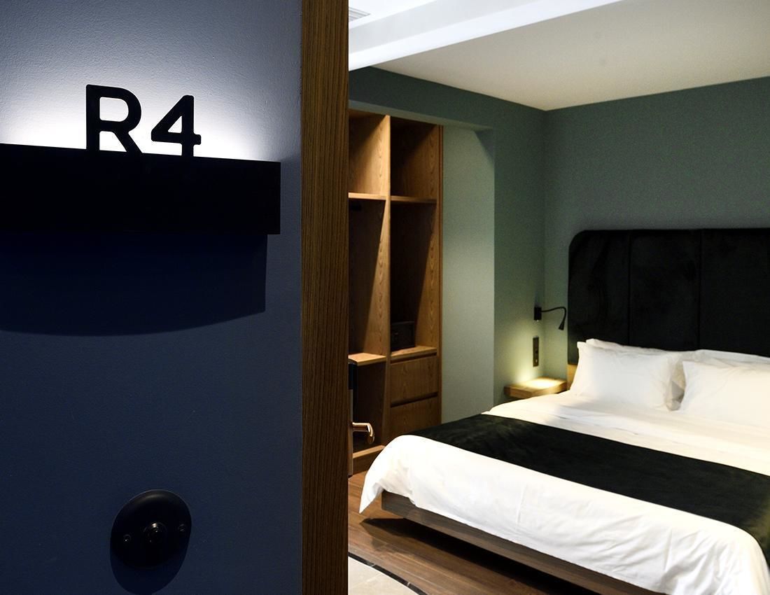 A hotel room with a bed, a wardrobe, and a nightstand.