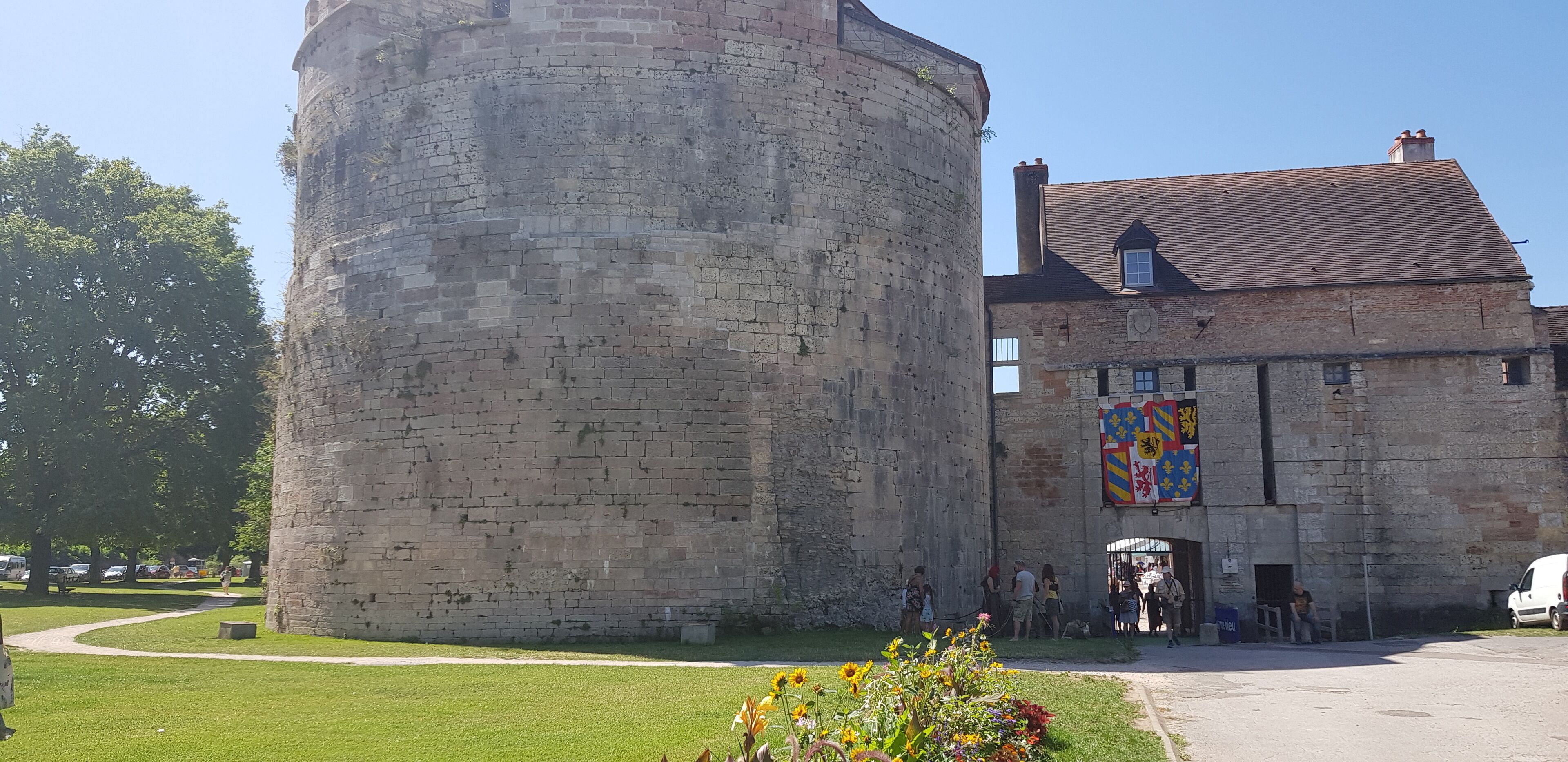 A historic stone tower and a building with a flag.
