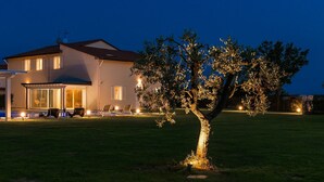 A modern house with a swimming pool, outdoor seating, and a well-lit tree. - Stunning private villa for 13 people with A/C, private pool, WIFI, hot tub, sauna, TV and patio (Cintolese)