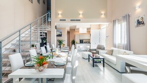 A modern living room with a dining area, a staircase, and a kitchen. - Stunning private villa for 13 people with A/C, private pool, WIFI, hot tub, sauna, TV and patio (Cintolese)