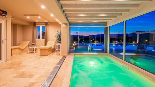 A modern indoor swimming pool with a view of a night-time landscape. - Stunning private villa for 13 people with A/C, private pool, WIFI, hot tub, sauna, TV and patio (Cintolese)