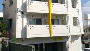 Een meerlaags gebouw met balkons en een centrale gele kolom.