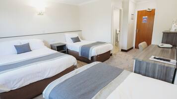 A hotel room with two beds, a desk, and a chair.