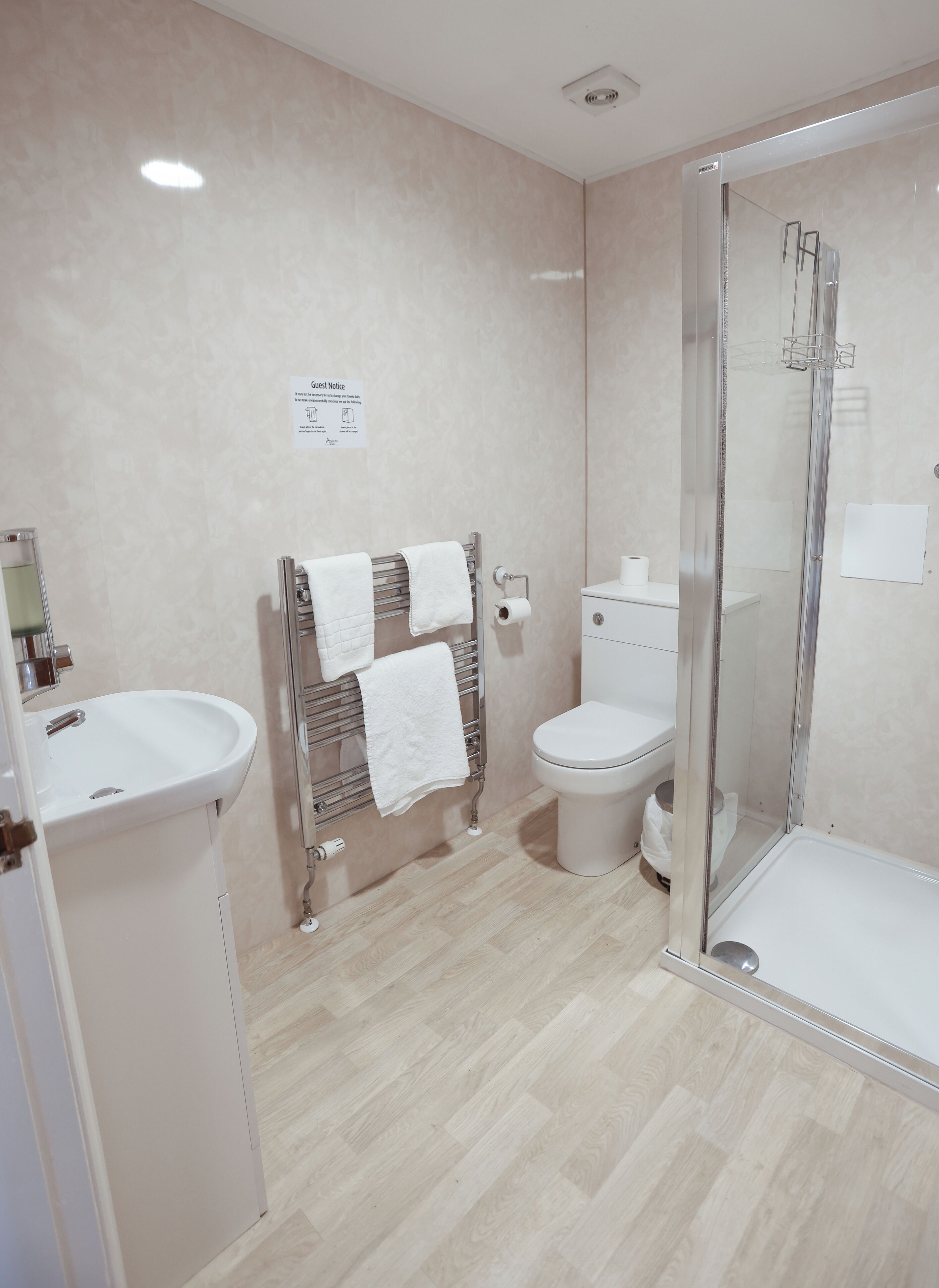 A modern bathroom with a shower, toilet, and sink.