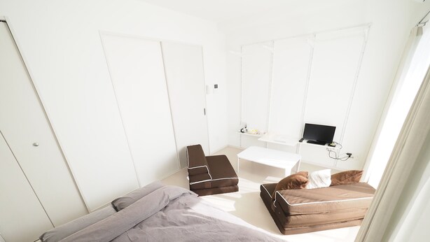 Ein Schlafzimmer mit einem Bett, einer Couch, einem Schreibtisch und einem Fernseher.
