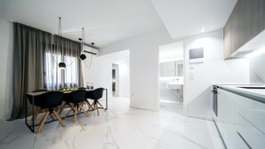 Una cocina moderna con armarios blancos y encimera de mármol.