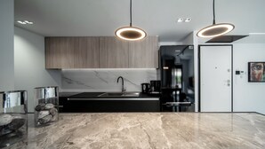 Una cocina moderna con encimera de mármol, armarios de madera y horno integrado.