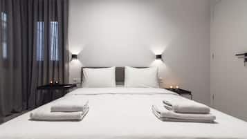 A modern hotel room with a large bed, two bedside tables with lamps, and a view of the city through the window.