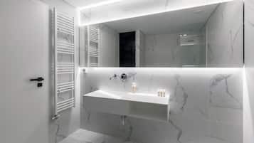 A modern bathroom with a white vanity, a large mirror, and a glass shower enclosure.