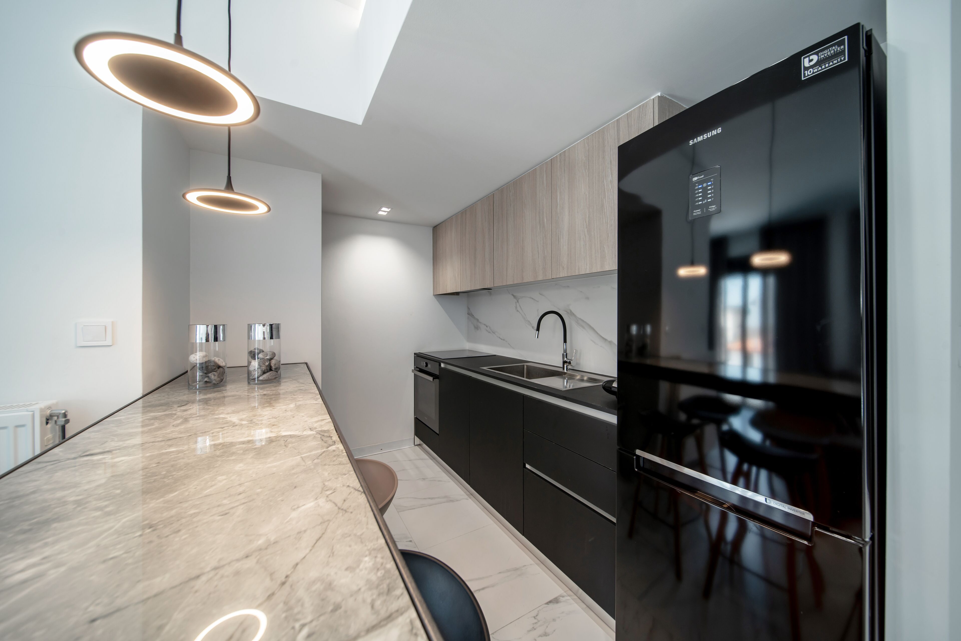 A modern kitchen with a large island, built-in appliances, and pendant lighting.