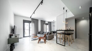 Una sala moderna con sofá, mesa de centro y comedor con taburetes.