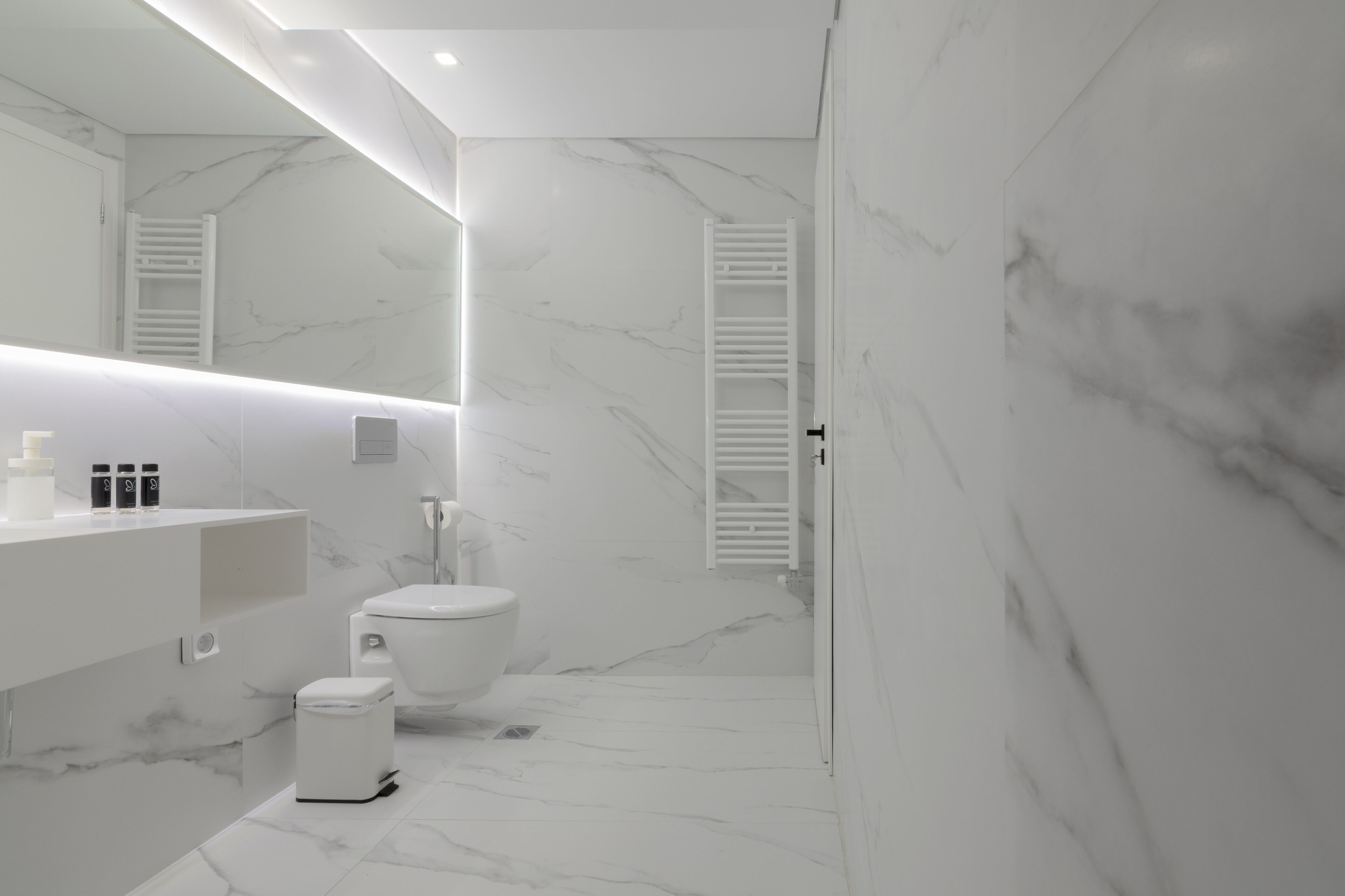 A modern bathroom with a toilet, sink, and mirror.