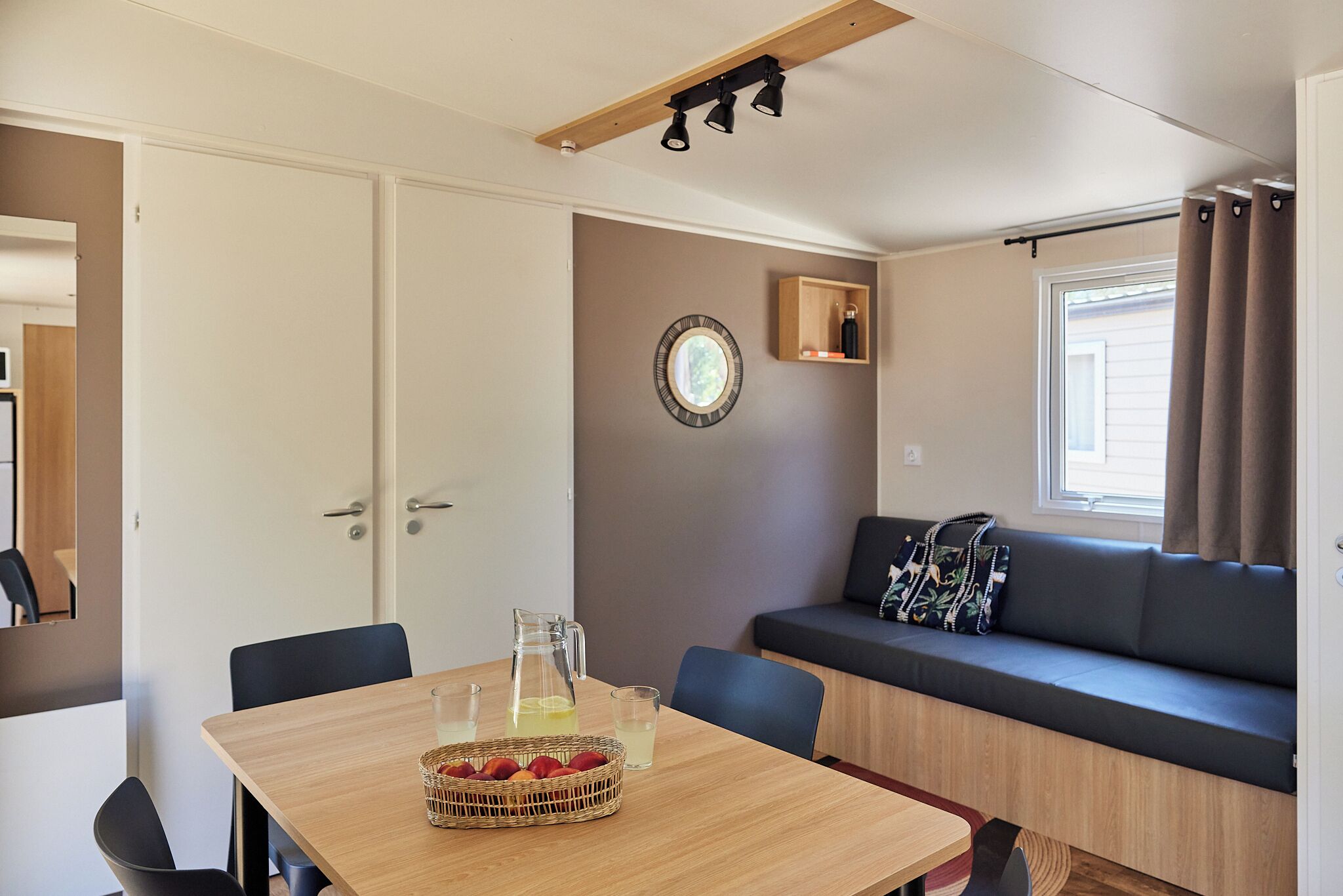 Una habitación acogedora con una mesa de madera, un sofá y una ventana con cortinas.