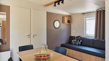 Una habitación acogedora con una mesa de madera, un sofá y una ventana con cortinas.
