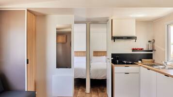 Una kitchenette compacta con estufa, pileta y alacenas.