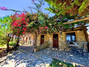 A stone building with a stone staircase, a wooden pergola, and a table with chairs. - Quinta do Mar - Country & Sea Village (Lagos)