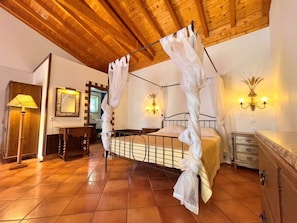 A four-poster bed with sheer curtains, a wooden ceiling, a nightstand with a lamp, and a wall-mounted light fixture. - Quinta do Mar - Country & Sea Village (Lagos)