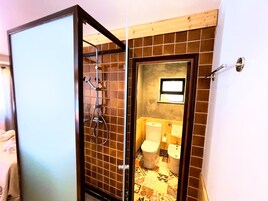 Casa de banho com cabine de duche, sanita e lavatório.
