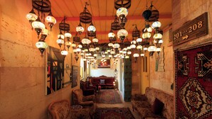 A traditional interior with ornate hanging lamps, patterned rugs, and classic furniture. - Kemal Stone House Hotel (Nevsehir)